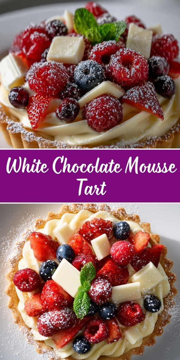 White chocolate mousse tart in a golden pastry shell with piped white chocolate mousse filling, topped with fresh raspberries, blueberries, strawberries, white chocolate curls, mint leaves, and dusted with powdered sugar.