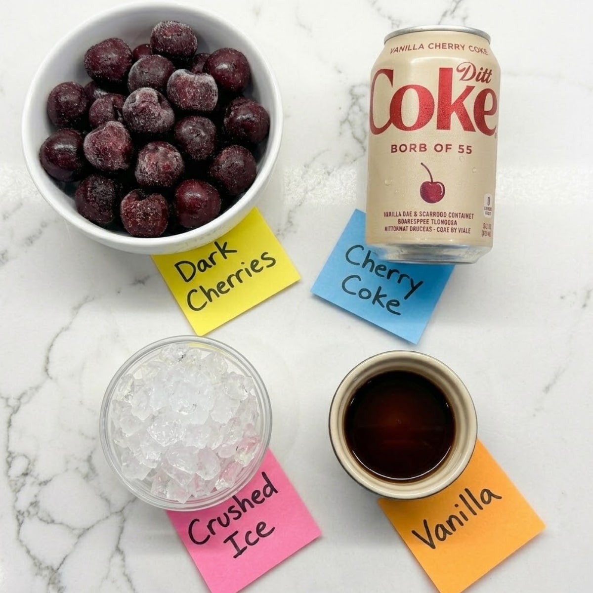 Tight knolling of frozen cherries, soda, and crushed ice with labels on a marble surface.