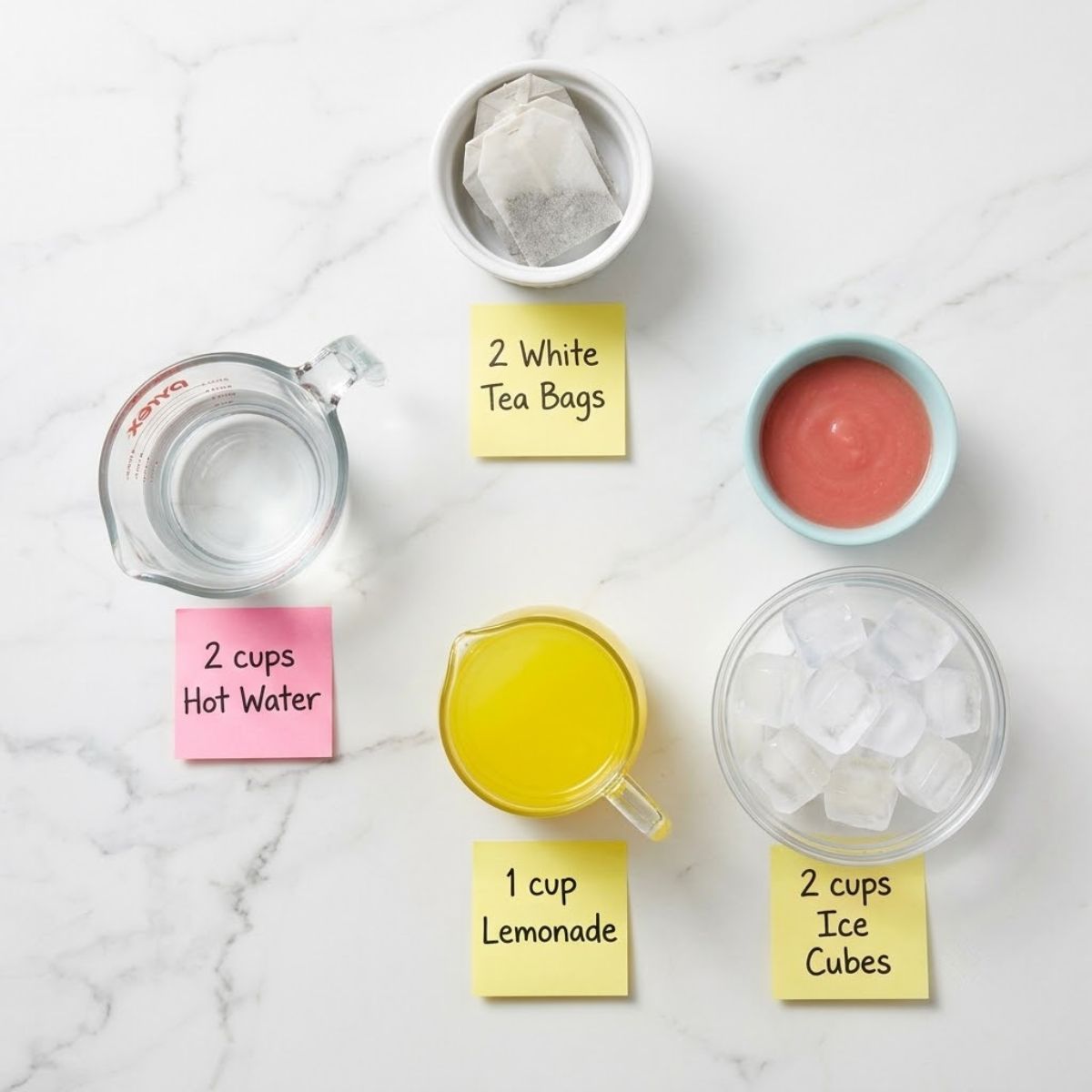 Flat lay of ingredients for Guava White Tea Lemonade with labeled sticky notes on a marble counter.