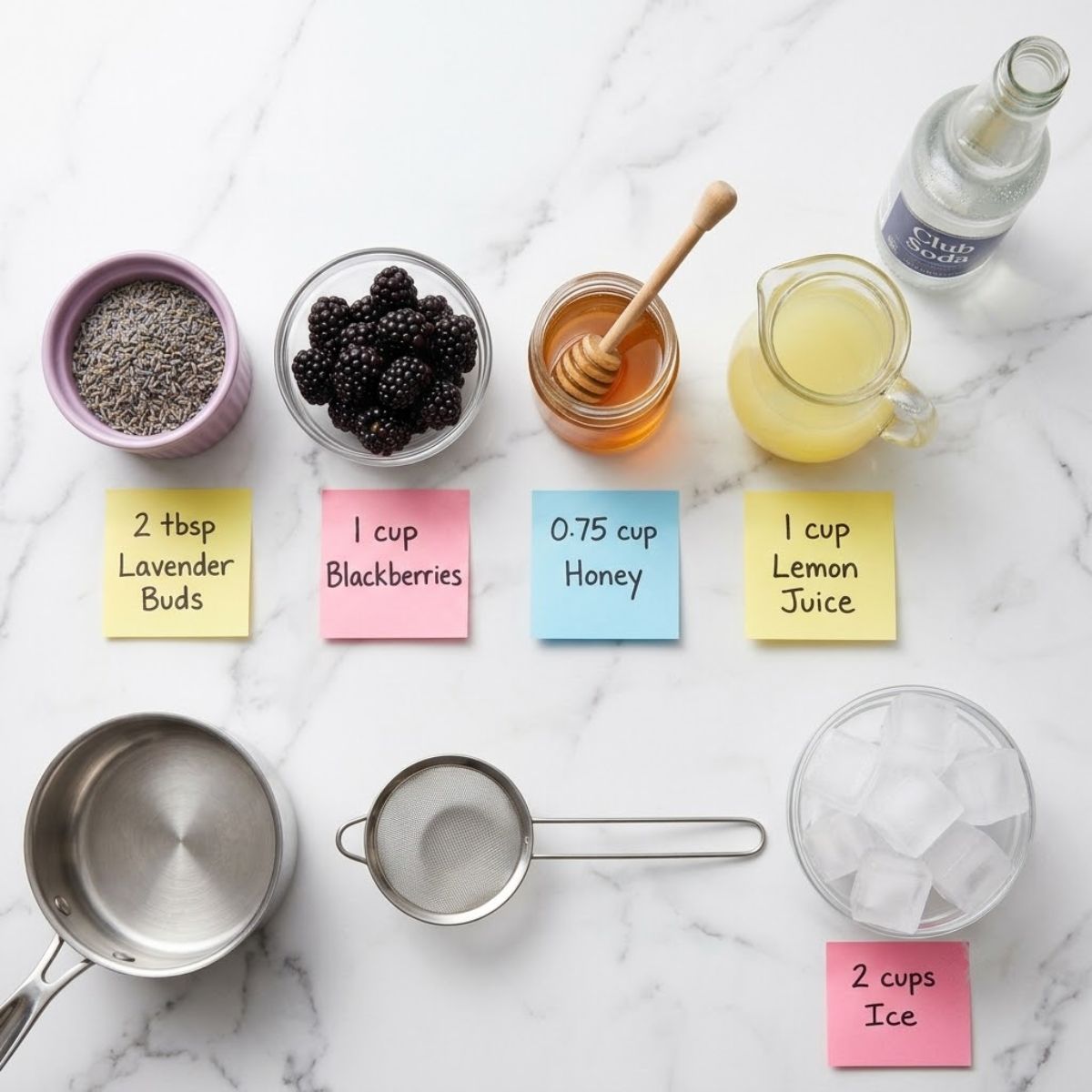 Flat lay of ingredients for Lavender Haze Mocktail with labeled sticky notes on a marble counter.