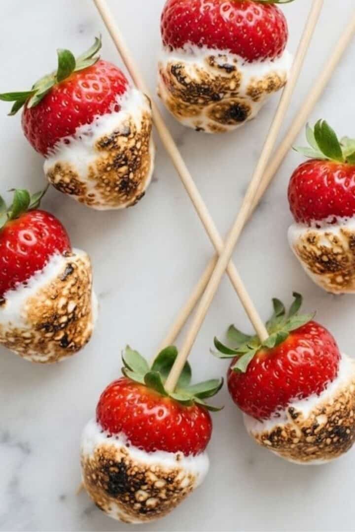An overhead top-down view of Toasted Marshmallow Strawberries placed on white marble kitchen counter.